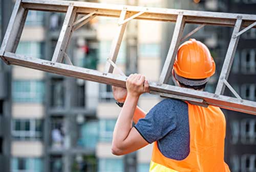 Maintenance worker holding metal ladder