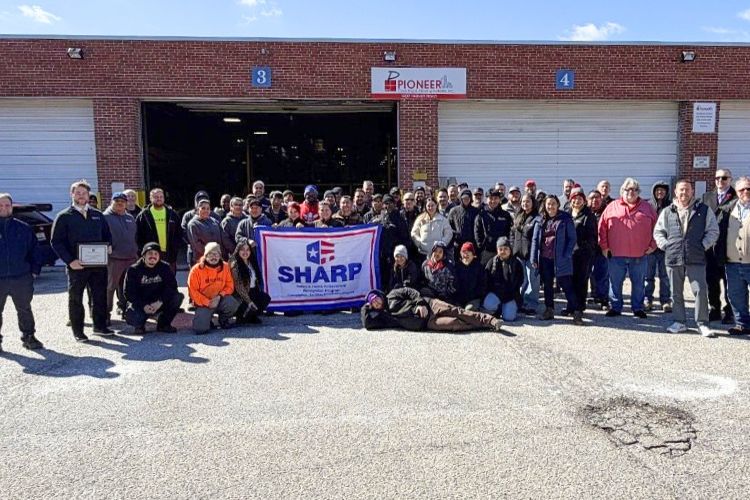 Pioneer employees holding a SHARP flag along with MOSH employees.